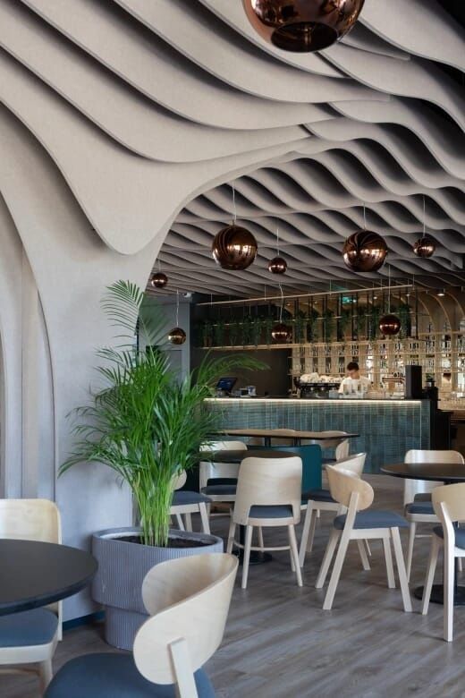 Modern cafe with sculpted acoustic ceiling and hanging globe lights